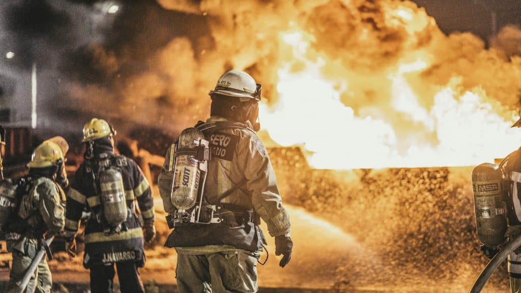 Firefighters standing in front of fire