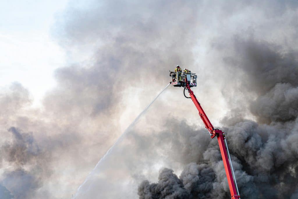 Firefighters Putting out Fire from an Extended Ladder