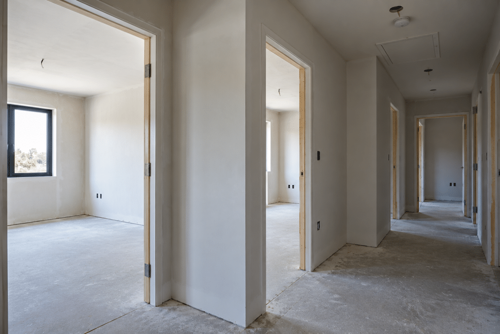 Unfinished interior corridor with multiple newly constructed partition walls and open doorways, illustrating that internal walls should not automatically be assumed to provide fire resistance.