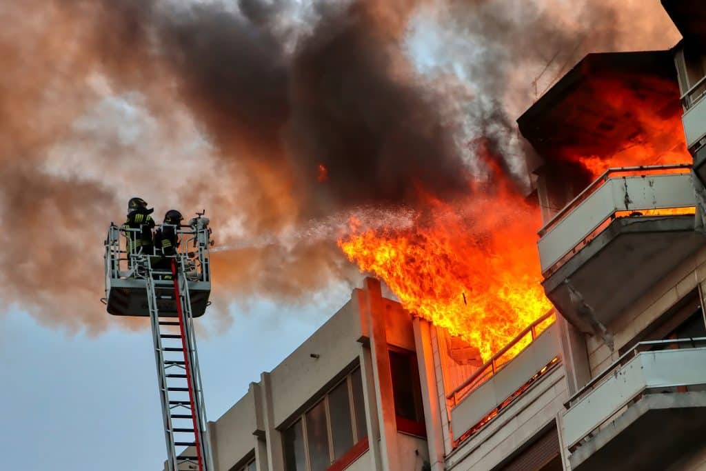 Italian firefighters at work during a fire in an attic of a building in an Italian city.,Apartment on fire and flames.